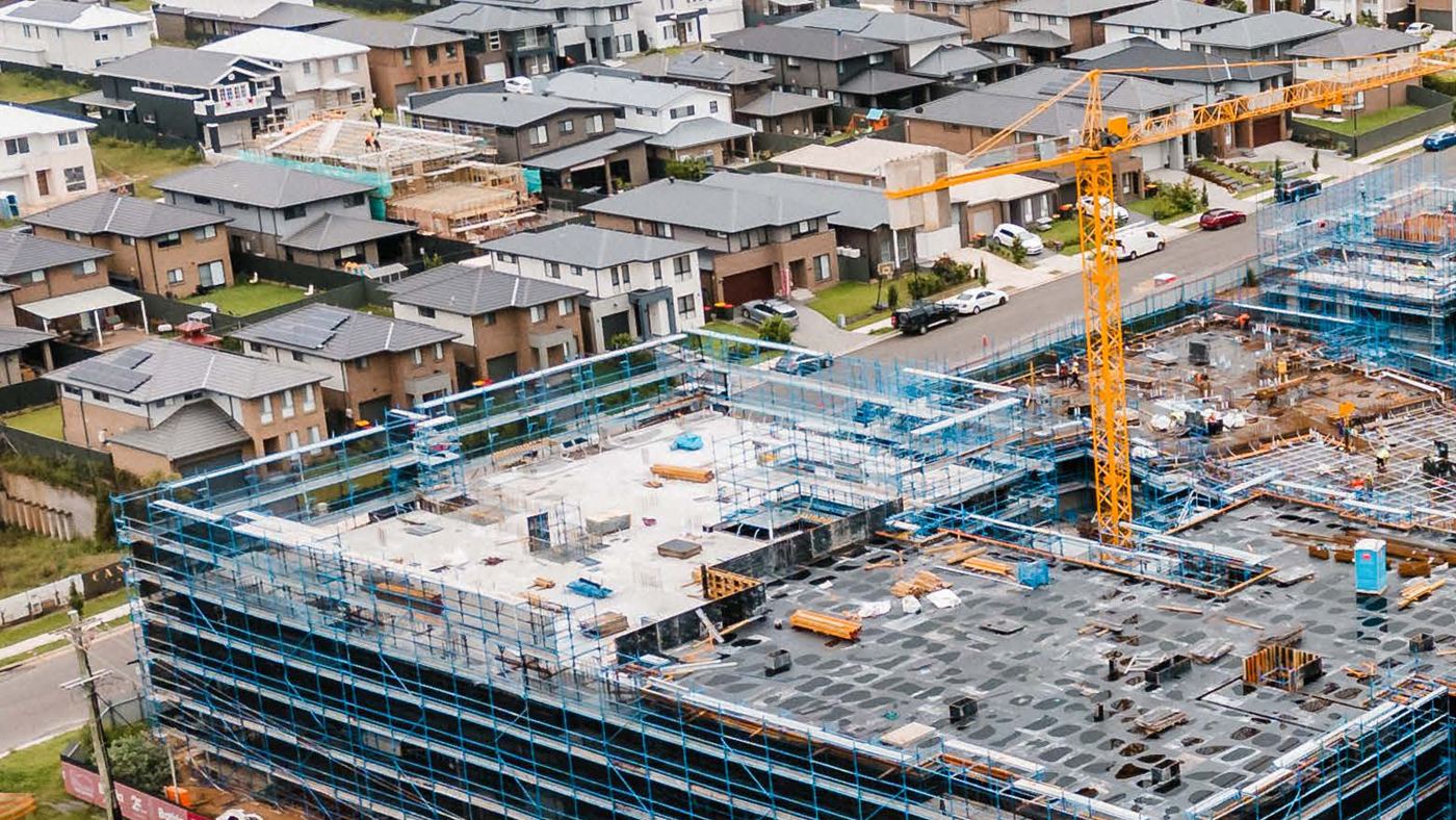 Formwork decks, blue scaffold and tower cranes on a live Sydney high-rise build